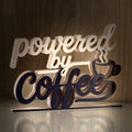 Powered by Coffee 3D printed word art on a wooden background
